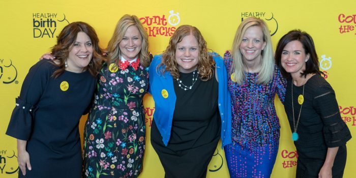 The Healthy Birth Day, Inc. Founders stand in front of a yellow backdrop