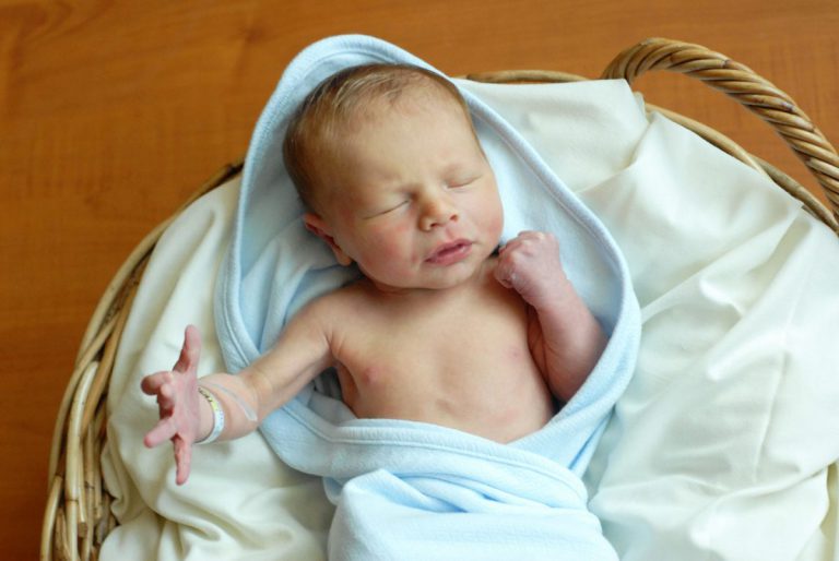 Baby Save Hayden is wrapped in a light blue blanket and sleeping in a basket