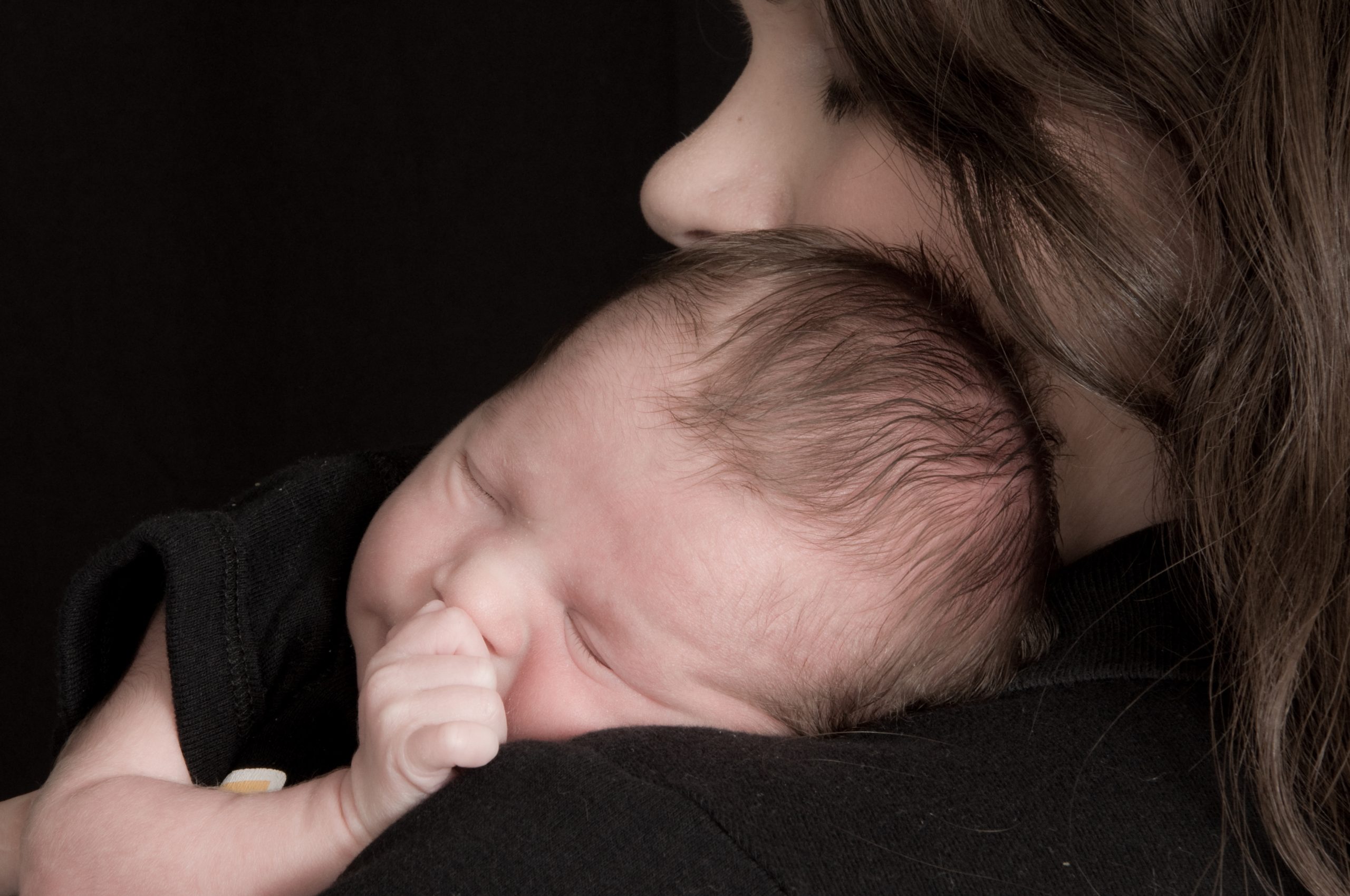 Baby save William snuggles on his mom's shoulder